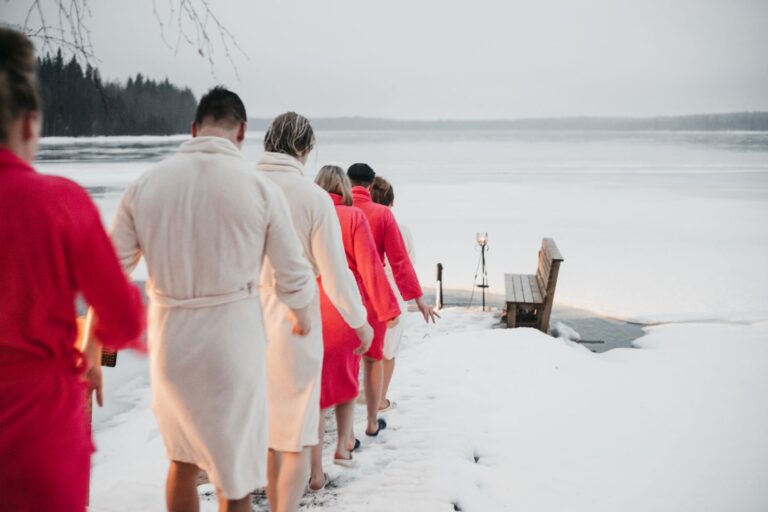 Kylpytakkeihn pukeutunut joukko menossa talvella avantoon.